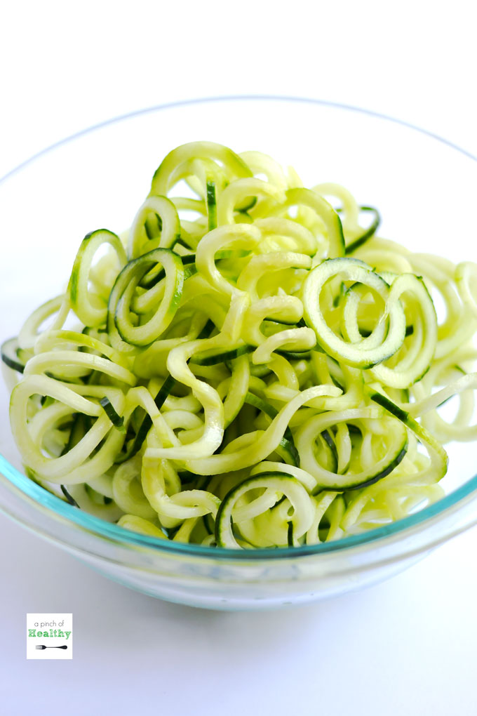 This spiralizer Greek salad is a light and refreshing side dish made with cucumbers, tomatoes, basil, chickpeas, feta cheese and balsamic vinaigrette. So easy and delicious! | APinchOfHealthy.com