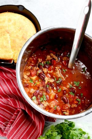 Instant Pot turkey chili in stainless pot with ladle