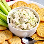 Chicken salad in a white bowl with crackers and celery
