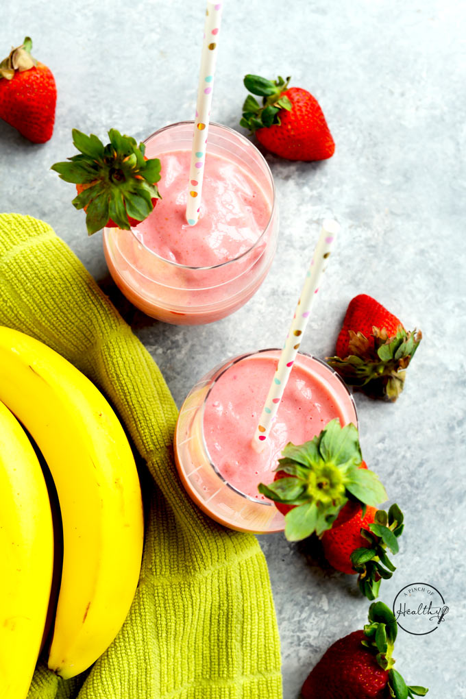 strawberry banana smoothies from overhead with fresh bananas and strawberries on gray surface