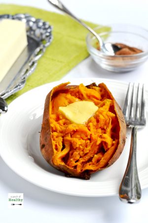 baked sweet potato with melting butter on white plate