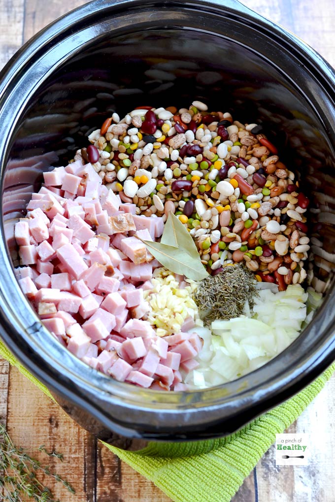 15 bean soup ingredients in a slow cooker before cooking, in individual piles