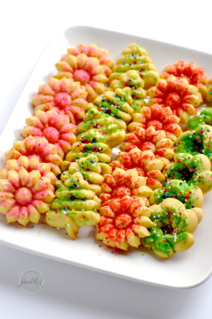 Red and green Christmas spritz cookies on white plate