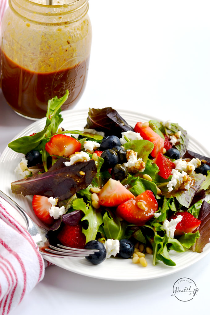 This summer salad with berries, goat cheese and pine nuts is such a simple and elegant dish, bursting with seasonal flavor. | APinchOfHealthy.com