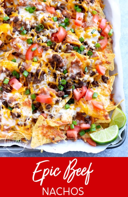 Sheet pan beef nachos supreme with refried beans, cheddar, Monterey Jack, tomatoes, and green onions
