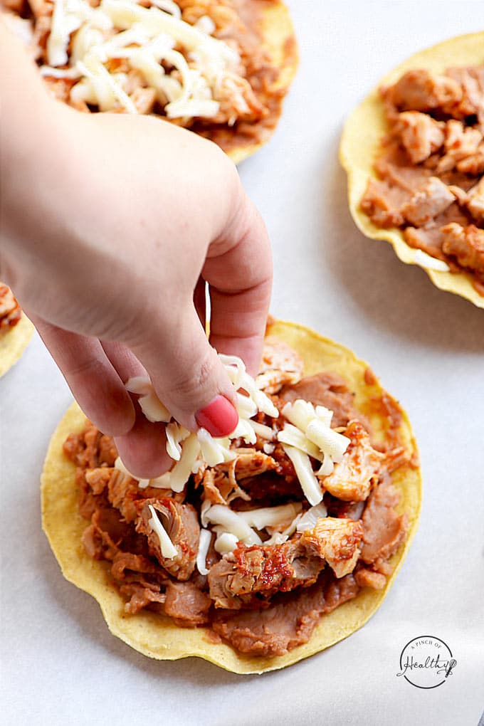 Chicken tostadas with refried beans, chicken, cheese, tomatoes, guacamole and sour cream
