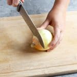 slicing off stem ends of onion