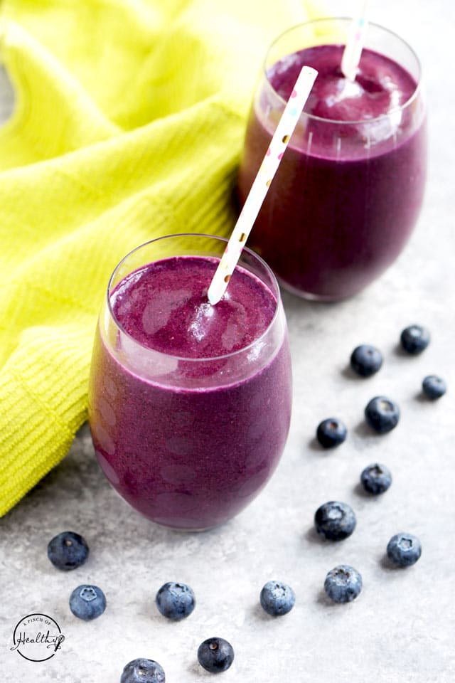 Blueberry smoothie with green towel and polka dot straws