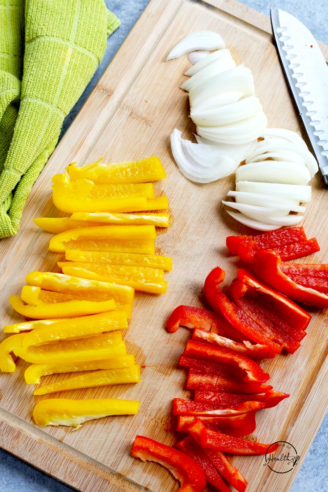 read and yellow bell pepper strip and onion strips on cutting board