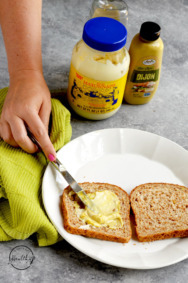 Spreading honey mustard on bread