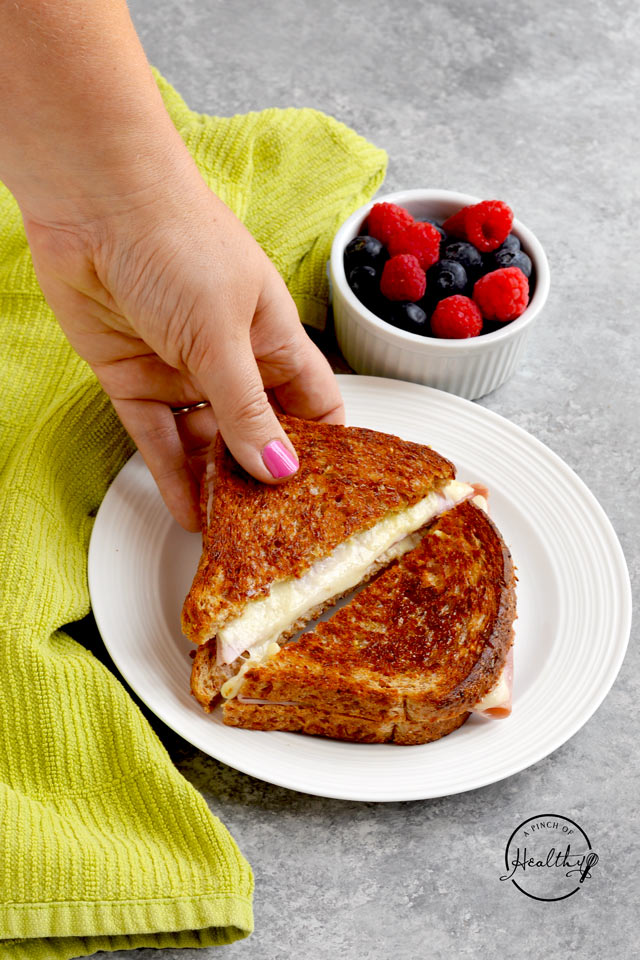 Grilled ham and cheese cut into triangles on a white plate