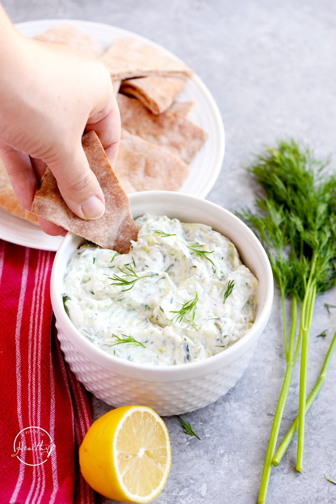 Dipping soft pita bread in tzatziki