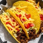 Ground beef tacos in a bowl with white paper liner