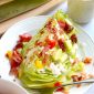 closeup wedge salad with tomato, bacon, cucumber and ranch