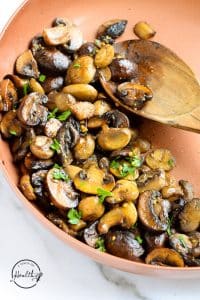 closeup sautéed mushroom in a copper pan