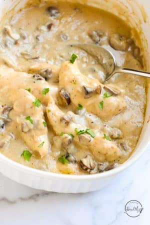 mushroom chicken tenderloins in white baking dish with parsley