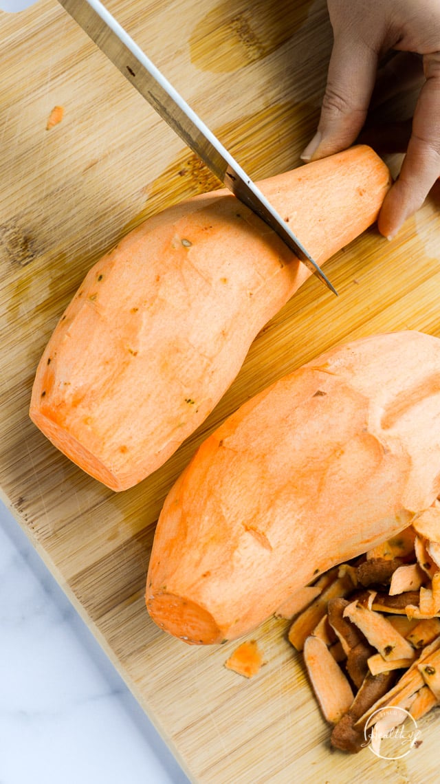 cutting sweet potato on wooden cutting board