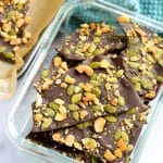 Salted dark chocolate bark with pumpkin seeds and cashews in clear rectangle bowl