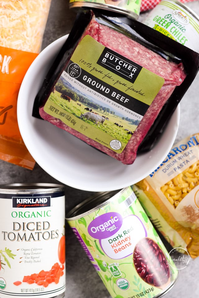 Ground beef, tomatoes, pasta and cheese on a gray table