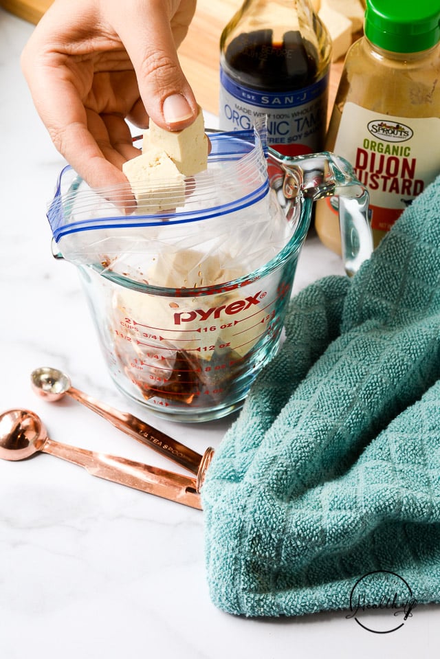 adding cubed tofu into marinade in a freezer bag
