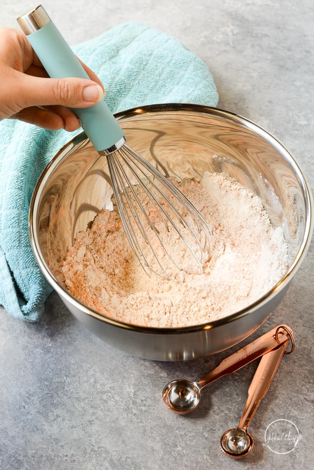 whisking dry ingredients together in stainless mixing bowl