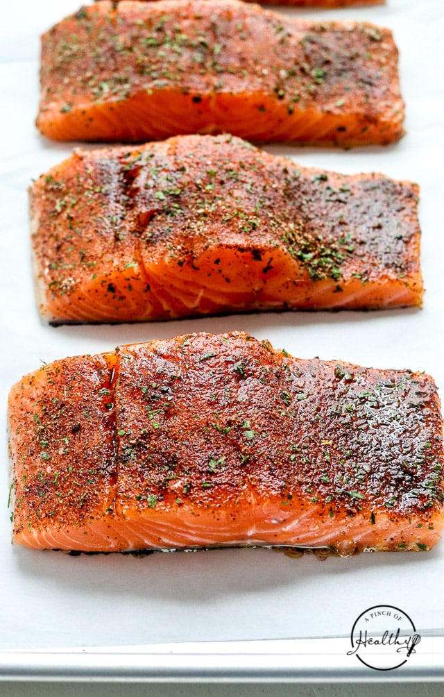 raw salmon seasoned on a baking sheet