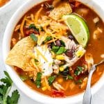 Slow cooker chicken tortilla soup in white bowl with corn chips