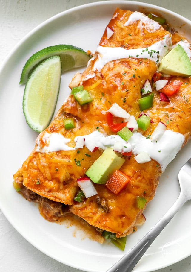 closeup shot beef enchiladas on white plate