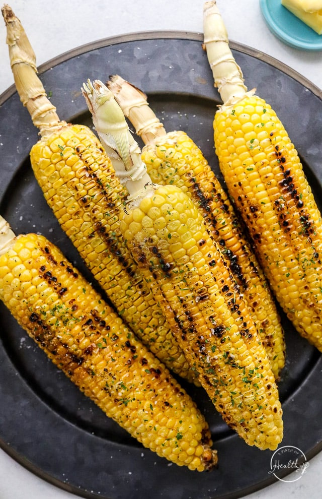 Grilled Corn on the Cob on dark plate with char marks