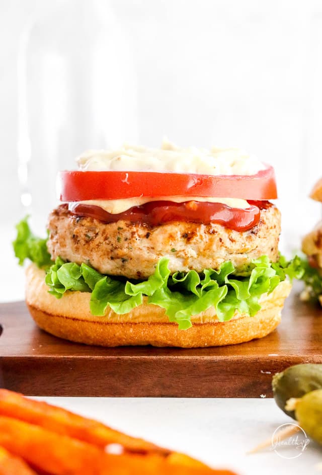 close up of grilled turkey burger with veggies