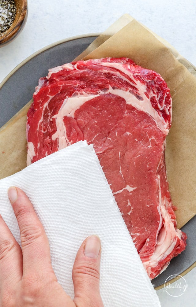 patting raw beef with paper towel