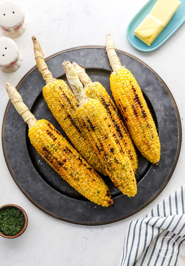 Grilled corn on the cob on a dark plate