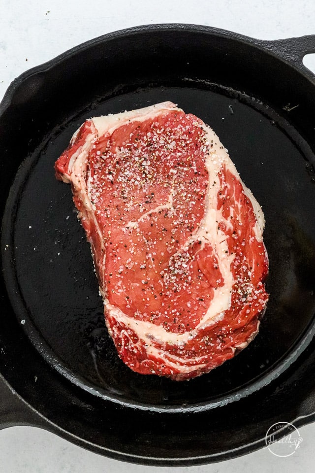 steak cooking in cast iron pan
