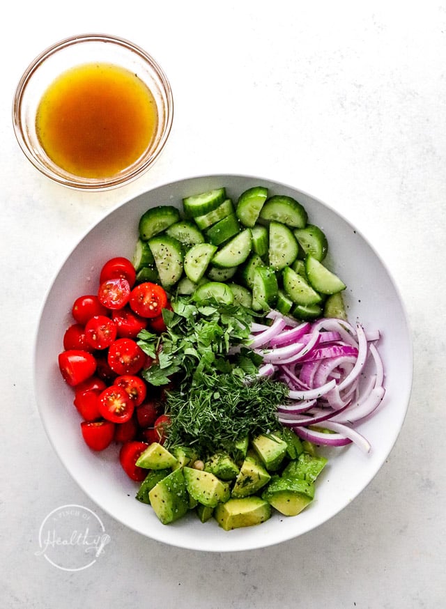 piles of veggies in a mixing bowl prior to tossing