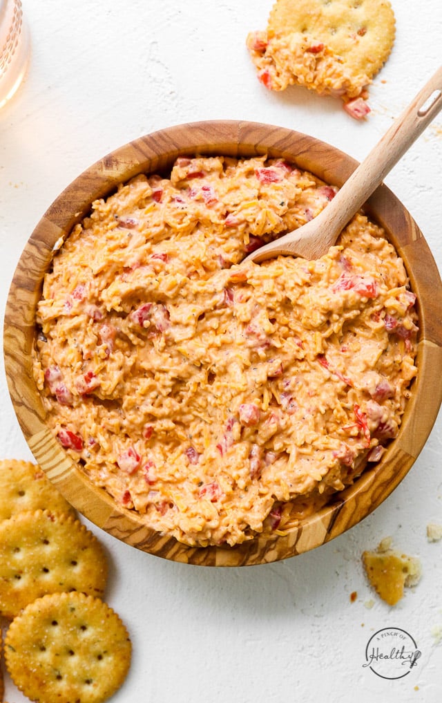 pimento cheese in wood bowl with spoon and crackers on the side