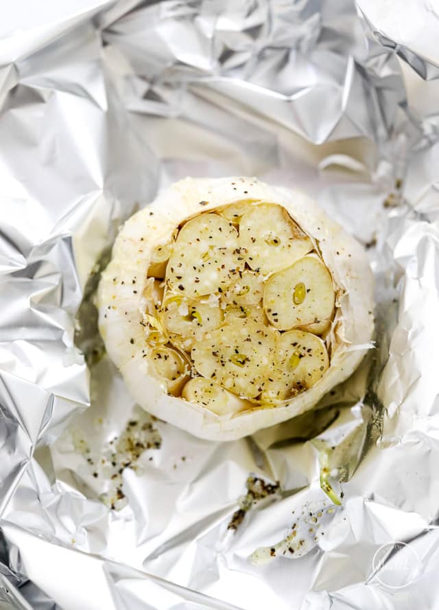 cut garlic in foil preparing to roast