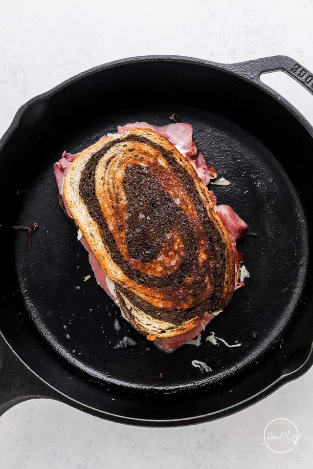 toasting sandwich in a cast iron pan
