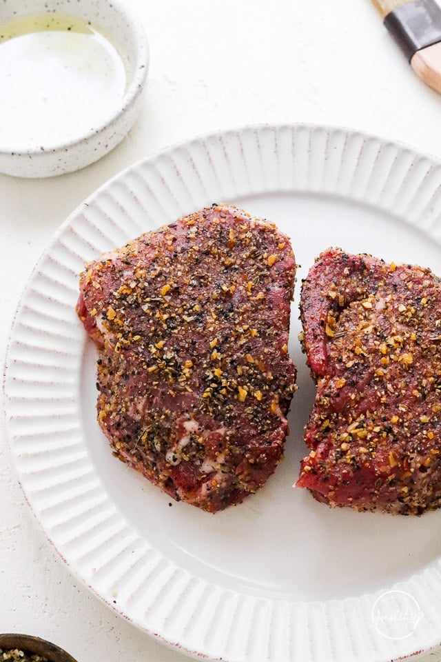 closeup of raw seasoned steaks