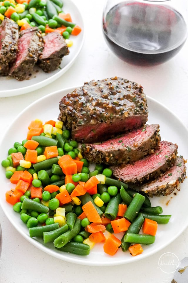 air fryer steak on white plate with veggies