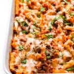 Closeup of baked ziti in white casserole dish