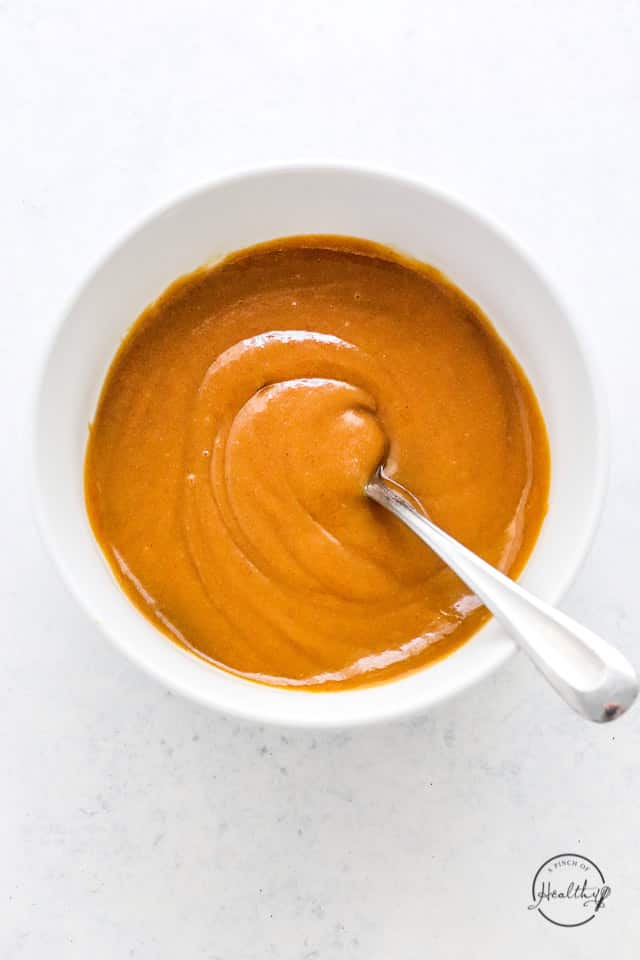 white bowl with Thai peanut dipping sauce and a spoon