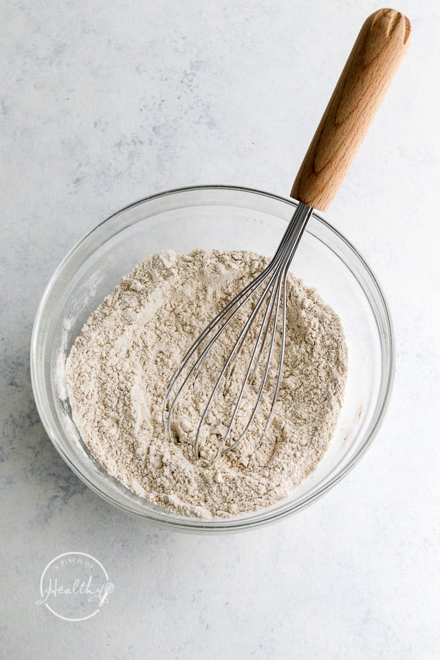 whisking dry ingredients in a clear glass mixing bowl