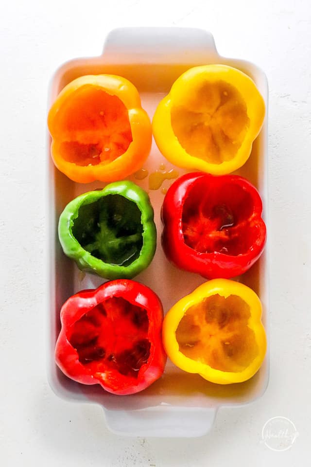 raw bell peppers in baking dish with tops cut off