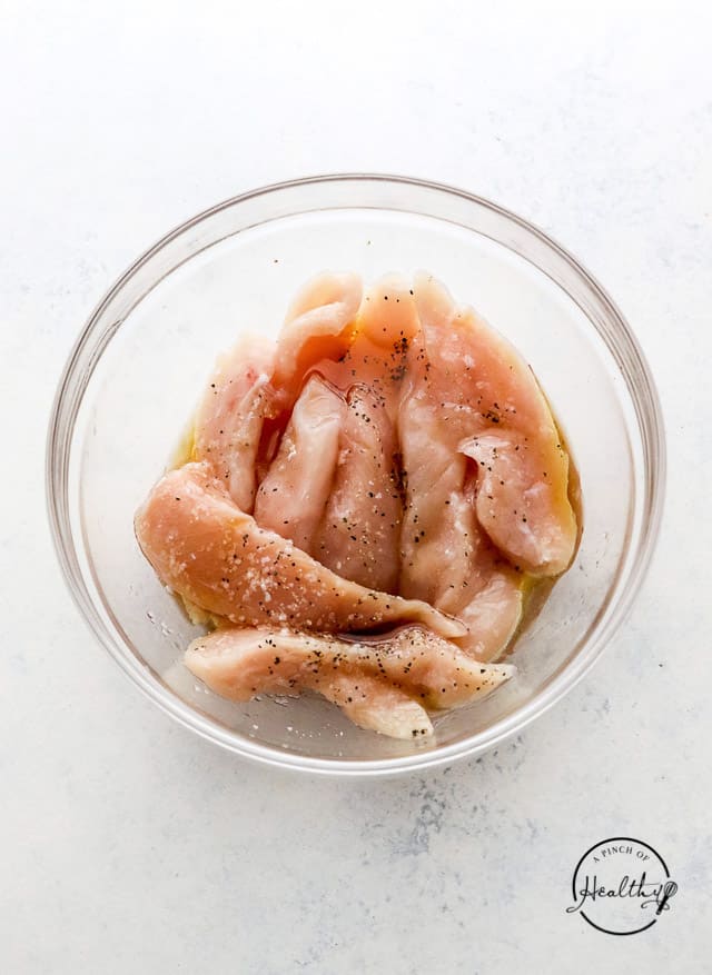 seasoning raw meat in a bowl