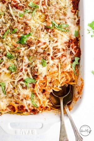 Baked Spaghetti Casserole in white dish with serving spoon