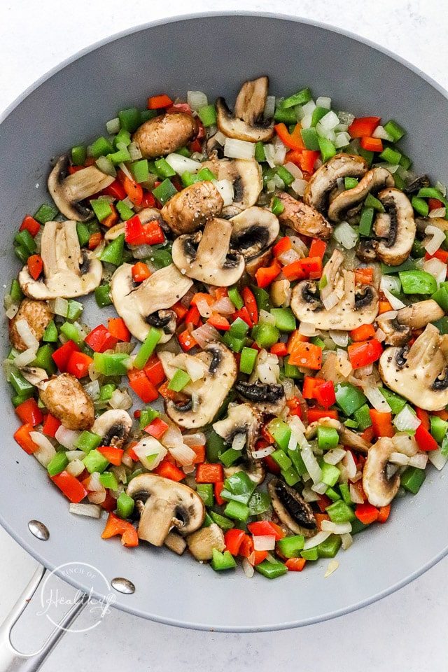 cooking onions, peppers and mushrooms in a pan