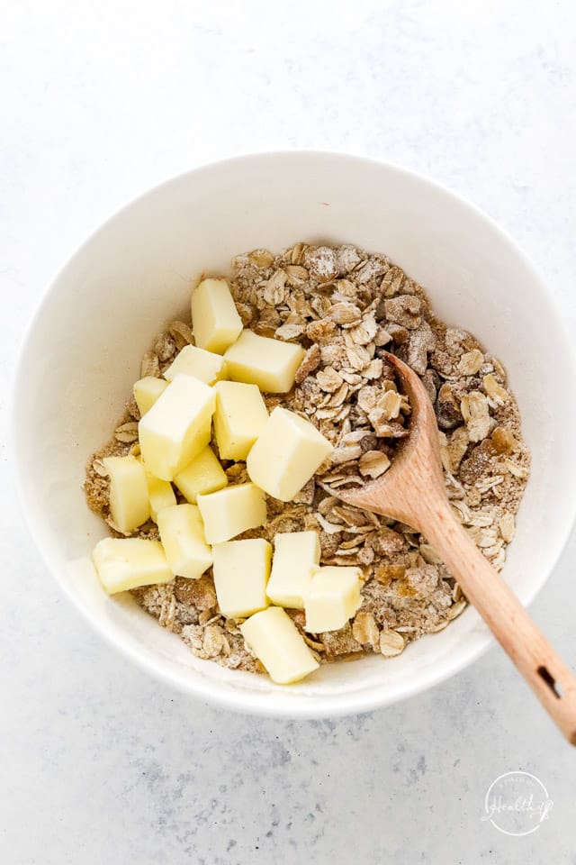 adding butter chunks to the blackberry crisp topping
