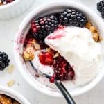 Blackberry crisp a la mode in white dish with spoon