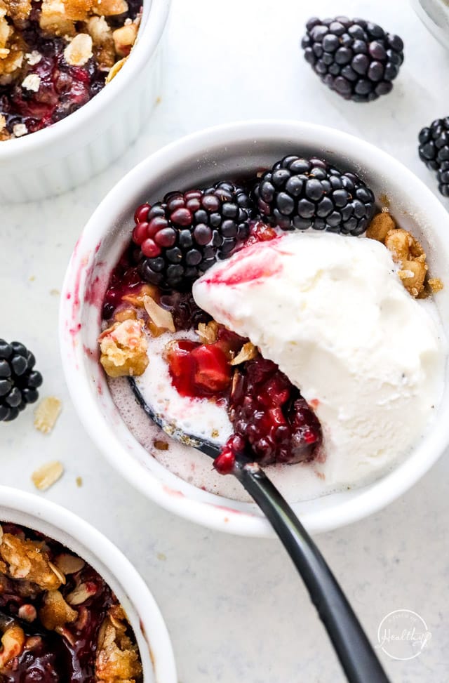 Blackberry crisp a la mode in white dish with spoon