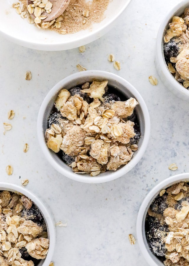 assembling blackberry crisp in ramekins